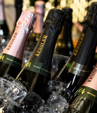 Mehrere Kessler Chardonnay Brut und Rosé Brut Flaschen in einem Eisbad