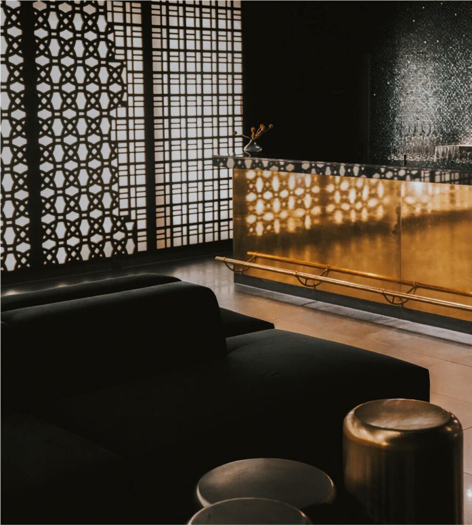 Eine stilvolle Bar mit eleganten goldenen Akzenten und schlanken schwarzen Möbeln.