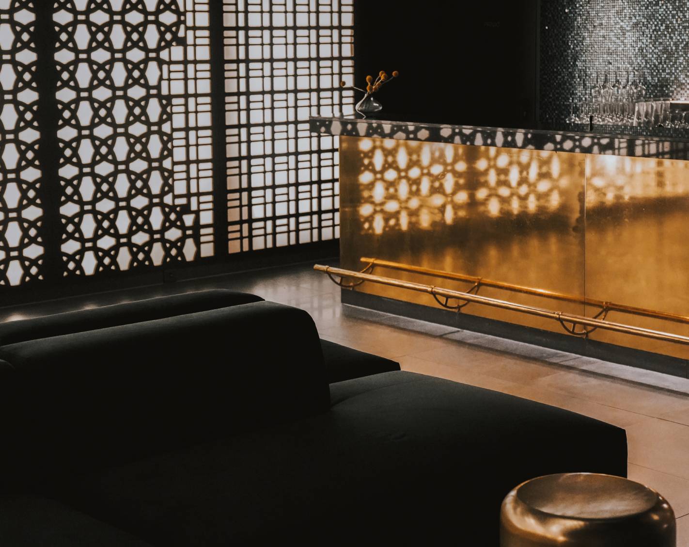 Eine stilvolle Bar mit eleganten goldenen Akzenten und schlanken schwarzen Möbeln.